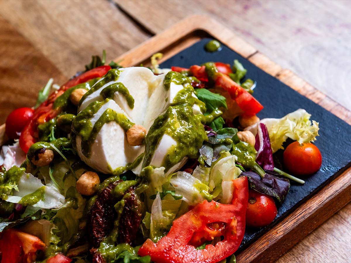 Mozzarella de búfala con pesto de hierbas mediterráneas, tomate seco y avellanas