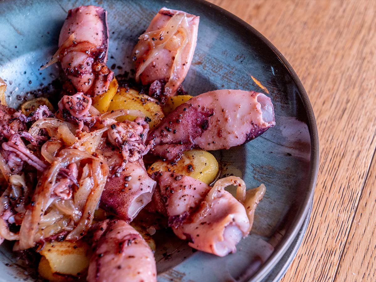 Chipirones encebollados con base de patatas panadera