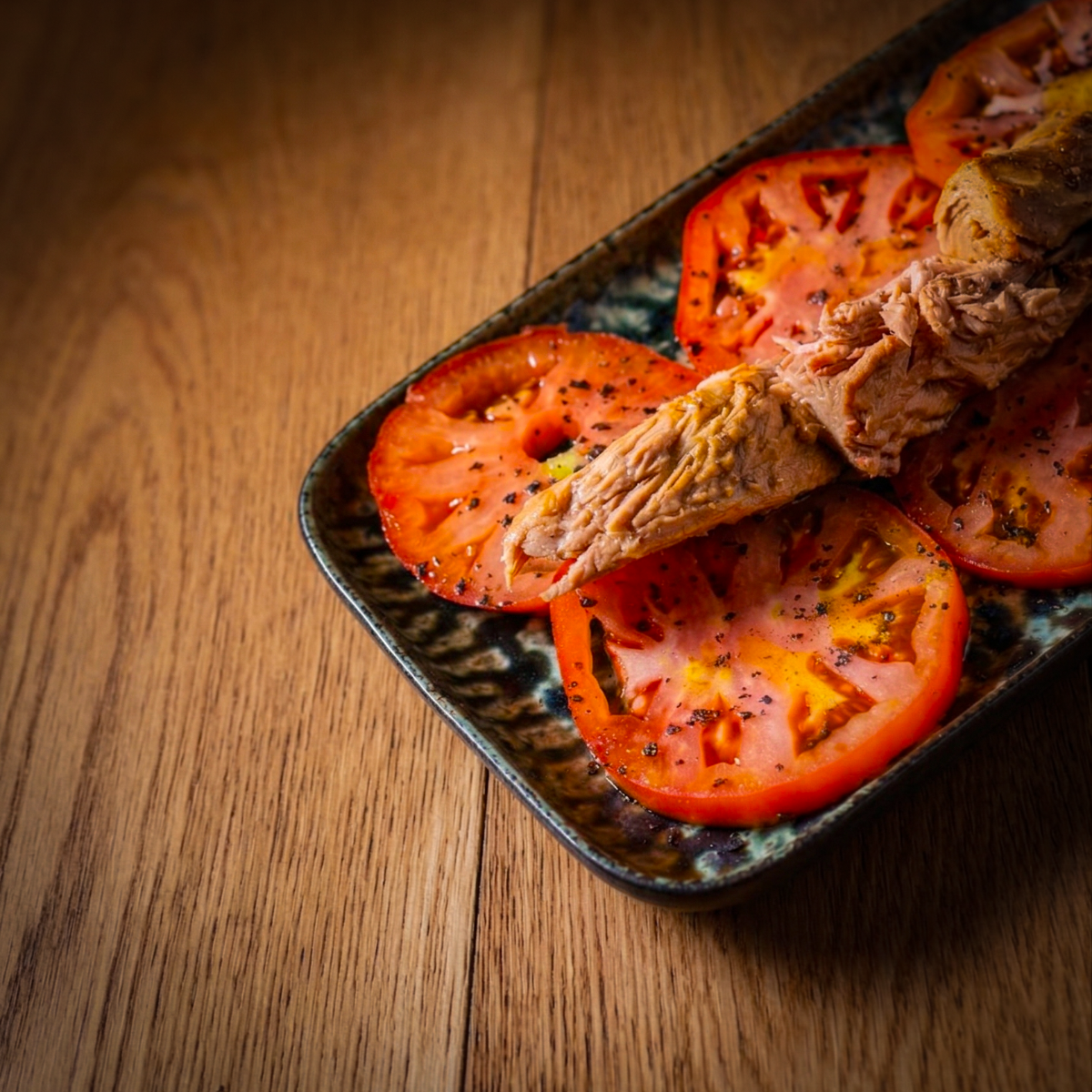 Ensalada de tomate de Vegastur con lomos de atún, sal negra y aceite de oliva negra